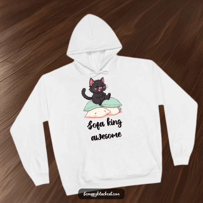 Funny scruffy black kitten hoodie, showing it joyfully launching itself onto a large pile of soft, inviting pillows.
