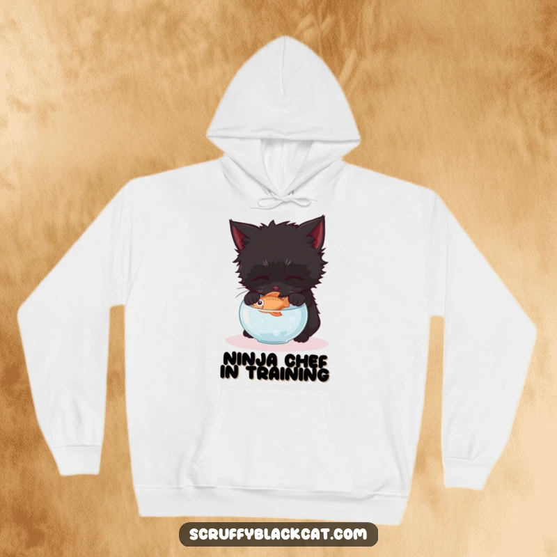 Funny scruffy black kitten hoodie, showing it gently attempting to steal a fish from a small, delicate bowl.