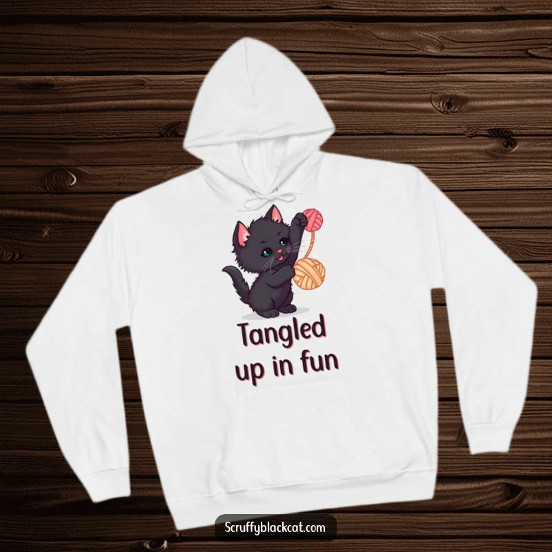 Funny kitten hoodie featuring a scruffy black kitten batting at a dangling yarn ball, a warm and humorous design.